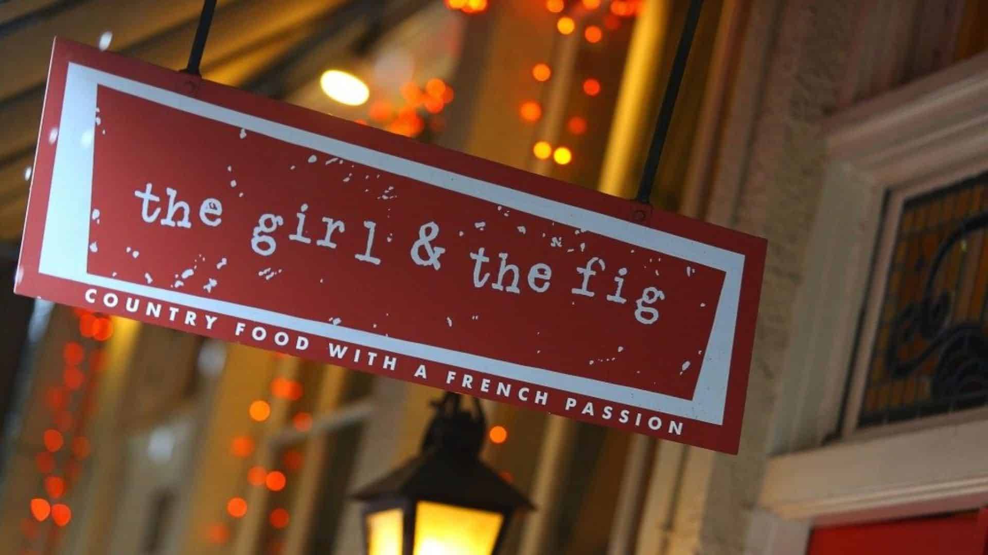 Rectangular red and white sign for a restaurant hanging outside of a building